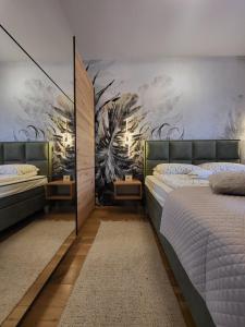 two beds in a bedroom with a mural on the wall at Apartman Restart Zlatibor in Zlatibor +29 photos