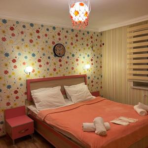 ein Schlafzimmer mit einem Bett und einer Uhr an der Wand in der Unterkunft Sheki Hilal Boutigue in Şəki