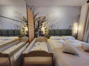 two beds in a room with a mural at Apartman Restart Zlatibor in Zlatibor