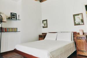 ミラノにあるLovelyloft - Alzaia Naviglioの白いベッド1台と壁に2枚の絵が飾られたベッドルーム1室が備わります。