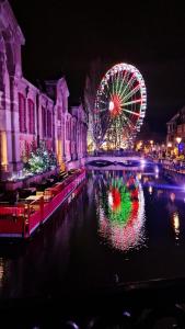 a city with a ferris wheel and a canal at night at NEW ! Vue Petite Venise, Place to be - Parking in Colmar