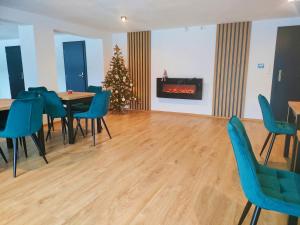 a living room with a christmas tree and a table and chairs at Kraina Rysia in Berezka