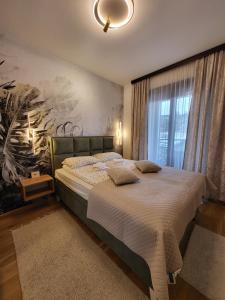 a bedroom with a bed with a painting on the wall at Apartman Restart Zlatibor in Zlatibor