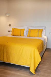 a yellow bed with two yellow pillows on it at Brand new Penthouse with Terrace in Athens