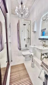 W łazience znajduje się toaleta z umywalką i żyrandol. w obiekcie Belle Époque w mieście Solingen