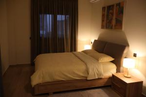 - une chambre avec un lit doté d'une lampe et d'une fenêtre dans l'établissement Element Suites - Red - Apt 1BD - Kalambaka, à Kalambaka