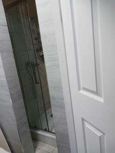 um chuveiro com uma porta de vidro na casa de banho em Amarillys Guest House em Preston