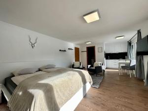 a bedroom with a bed and a living room at Cozy loft for 2 near zermatt in Täsch