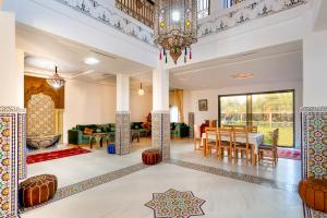 un salon avec un lustre et une salle à manger dans l'établissement leila farmhouse, à Marrakech