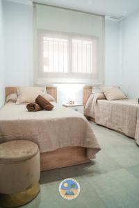 1 Schlafzimmer mit 2 Betten, einem Stuhl und einem Fenster in der Unterkunft Estrella Del Mar in San Juan de los Terreros