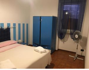 a bedroom with a blue cabinet and a fan at Residence La Quiete in Taureana