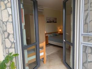 een kamer met glazen schuifdeuren naar een slaapkamer bij Apartments Mirian in Petrovac na Moru