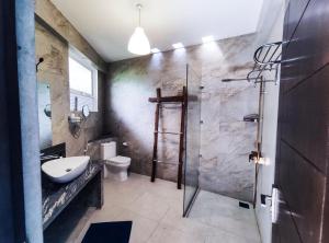 a bathroom with a shower and a sink and a toilet at The Yacht Riverside Villa Near Colombo International Airport in Ganepola +36 photos