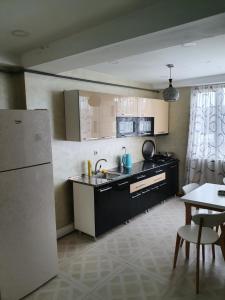 uma cozinha com um lavatório, um frigorífico e uma mesa em Marjanishvili16 53B em Tbilisi