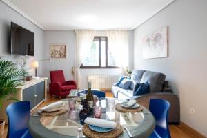 sala de estar con mesa y sillas azules en Apartamento Go - La Ermita, en Arroyo de la Encomienda