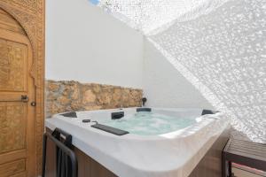 a bath tub in a room with at Seaside Tranquility and Urban Luxury - Stylish Duplex in Torremolinos w jacuzzi in Torremolinos