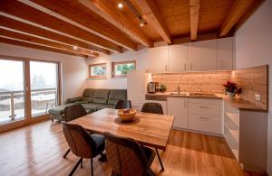 cocina y sala de estar con mesa de madera y sillas en Appartments Urmonti, en Schruns