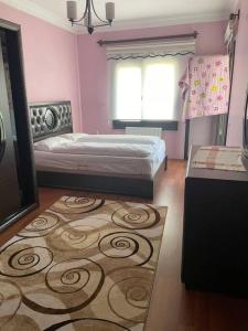 Dormitorio rosa con cama y alfombra en Coy Apartments Kayseri #1, en Talas