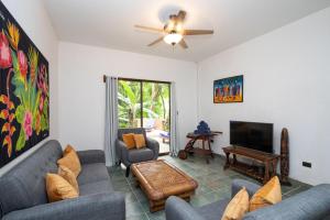 a living room with couches and a flat screen tv at 4BR Villa MotMot in w exclusive pool Wifi AC in Quepos