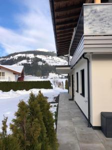 a white house with snow on the ground at Appartement Edelschwarz in Westendorf