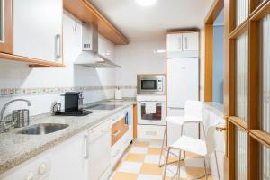 a kitchen with white cabinets and white appliances at Apartamento GO- La Ermita -Parking Gratuito in Arroyo de la Encomienda