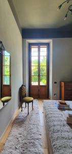 a living room with a door and a chair and a rug at Curt da Beta - Casa vacanze con giardino in Corte del XVIII secolo in Malnate