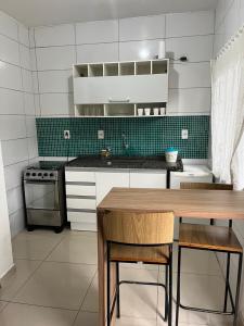 uma cozinha com uma mesa e um fogão em Pousada Jardim Da Lagoa em Florianópolis