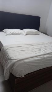 a large bed with white sheets and pillows on it at Niks home stay - A in Trichūr