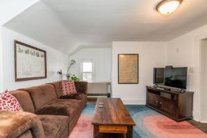 a living room with a couch and a flat screen tv at Ideally located 2BR Winooski Apt in Winooski +9 photos