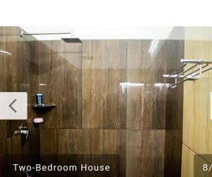 a bathroom with a shower with a wooden wall at Niks home stay - A in Trichūr