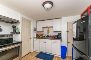 a kitchen with white cabinets and a blue rug at Ideally located 2BR Winooski Apt in Winooski