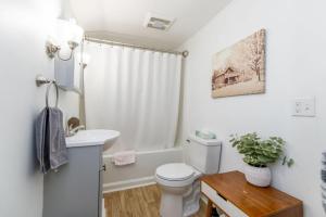 a white bathroom with a toilet and a sink at Ideally located 2BR Winooski Apt in Winooski