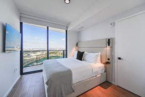 ein Schlafzimmer mit einem großen Bett und großen Fenstern in der Unterkunft Captivating Bayside Apartment at Downtown Miami in Miami