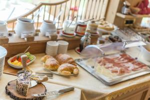 a buffet of food on a table with bread and pastries at Garni la Bercia in Selva di Val Gardena