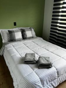 a white bed with two pillows on top of it at Sabaneta-Apto familiar in Sabaneta