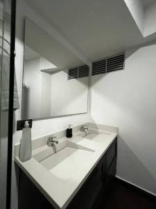 a white bathroom with a sink and a mirror at Sabaneta-Apto familiar in Sabaneta