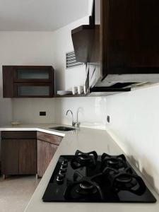 a kitchen with a black stove top in a kitchen at Sabaneta-Apto familiar in Sabaneta