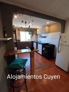 cocina con mesa y nevera en Alojamientos CUYEN para 4 personas Playa Quequen y El Faro en Quequén