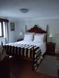 una camera da letto con un grande letto con cuscini bianchi di ABRIGO DO CABECINHO - SERRA DA ESTRELA a Cortes do Meio