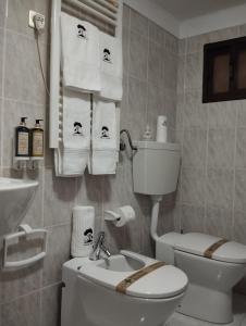 a bathroom with a toilet and a sink and towels at ABRIGO DO CABECINHO - SERRA DA ESTRELA in Cortes do Meio