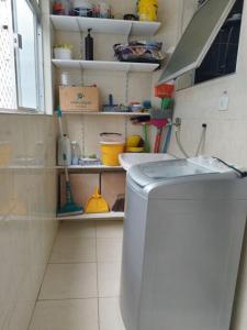 baño con lavadora en una habitación en Atravessou a rua tá na praia en São Vicente
