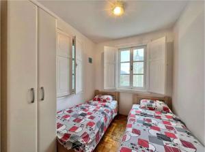 dwa łóżka w pokoju z dwoma oknami w obiekcie Apartment Old town Milica w mieście Herceg Novi