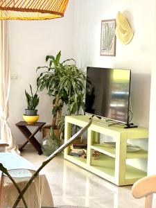 a living room with a television on a tv stand at DIVINO LUC, frente a la Cala Racó del Corb in Altea