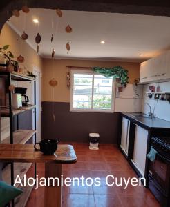 cocina con mesa y ventana en Alojamientos CUYEN para 4 personas Playa Quequen y El Faro en Quequén