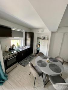 a kitchen and dining room with a table and chairs at Welcome to Bucharest Airport Residences & Therme-SELF CHECK-IN in Otopeni
