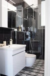 a white bathroom with a toilet and a shower at PARIS Opulent Lifestyle in Drama