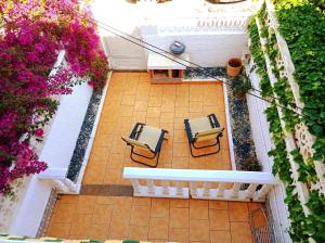 einen Blick über eine Terrasse mit Stühlen und Blumen in der Unterkunft Maravilloso Bungalow in Gran Alacant