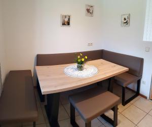 uma mesa de madeira com um vaso de flores em Apartment Morgensonne em Oberau