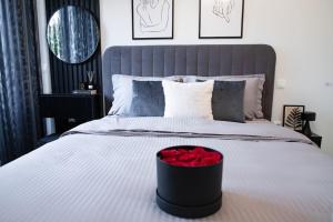 um quarto com uma cama com uma caixa preta com rosas vermelhas em PARIS Opulent Lifestyle em Drama