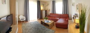 a living room with a red couch and a tv at Apartment Morgensonne in Oberau